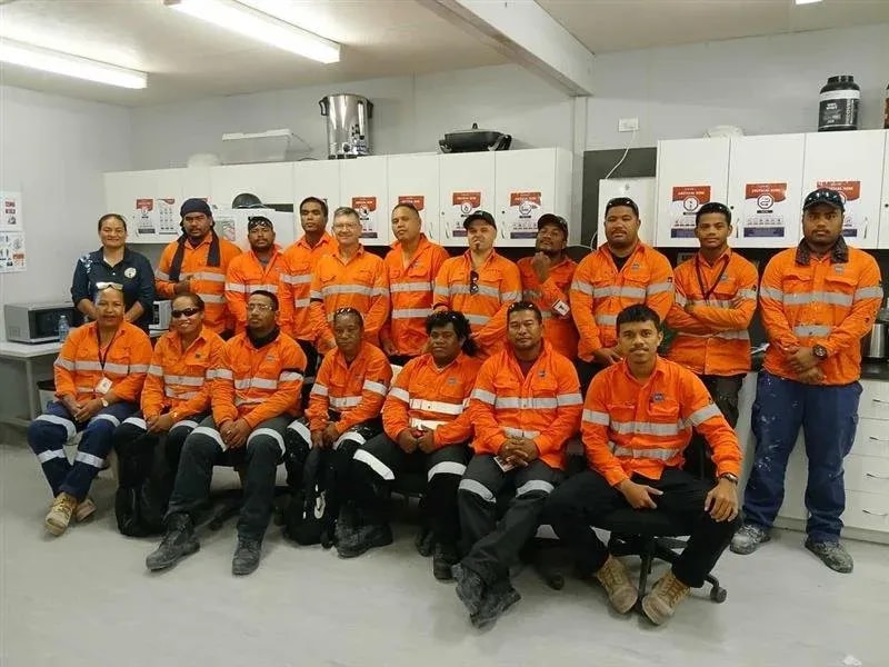 Group of workers in orange safety uniforms in a completed kitchen
